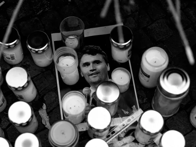 Charlie Kirk's photograph lays under some candles at a vigil held after his assassination